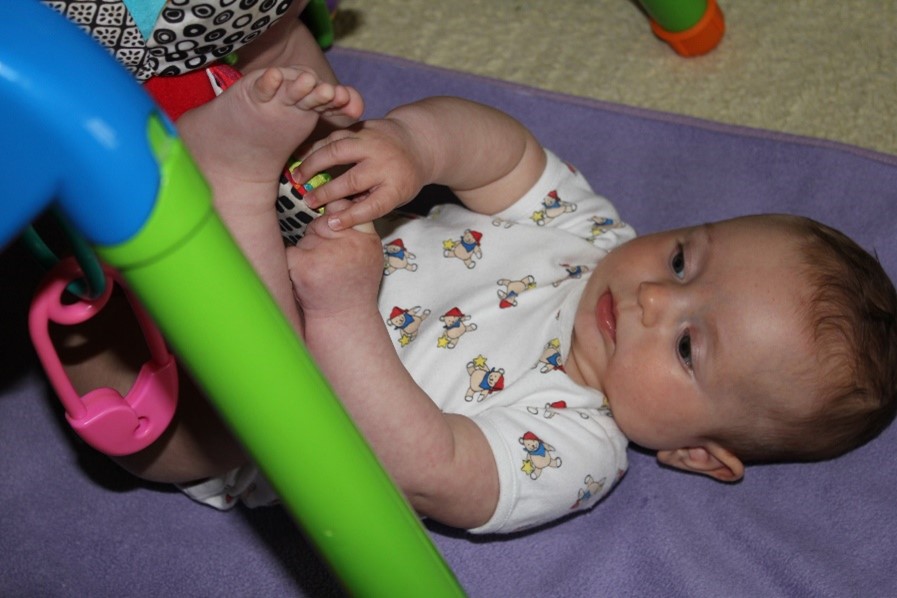 dítě na dece pod hrazdičkou