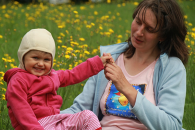 žena a dítě na žlutě rozkvetlé louce