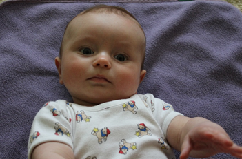 dítě s nahnutou hlavičkou na dece