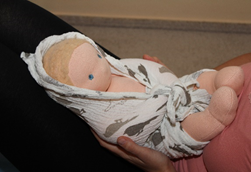 dítě zavinuté v pleně na klíně